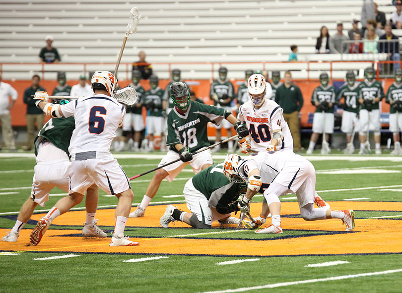 Syracuse wings Luke Schwasnick (6) and Bobby Tait (40) try to box out as Ben Williams fights for the faceoff.