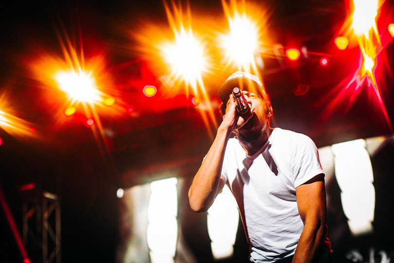 Chance The Rapper fiercely raps to a crowd echoing his words.