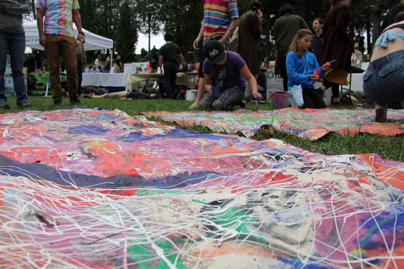 Students and Syracuse community members paint banners at Earthfest on Sunday.