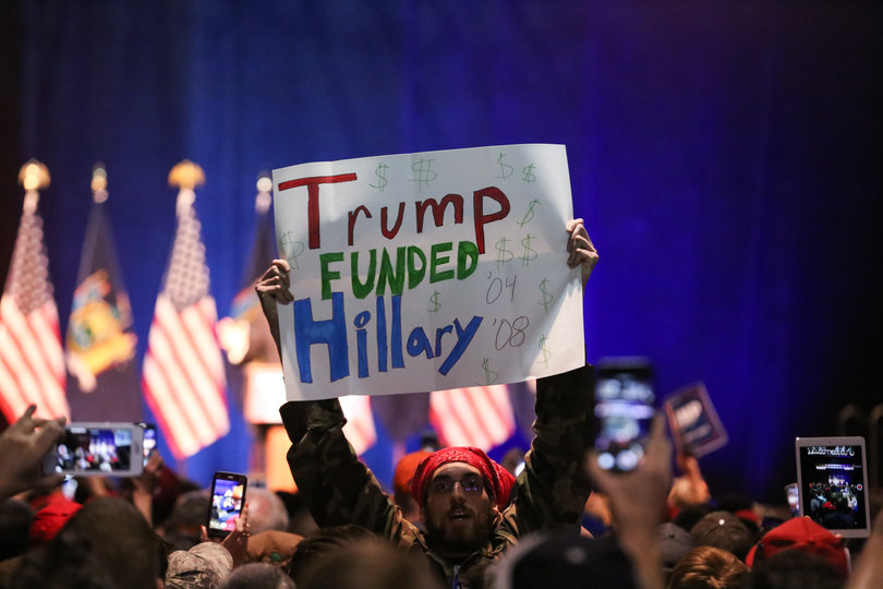 One Trump protester holds a sign highlighting Trump's past contributions to Democratic frontrunner Hillary Clinton