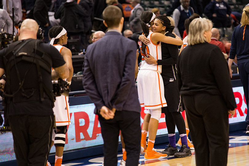 Briana Day (50) embraces with a player from Washington following SU's 80-59 victory. 