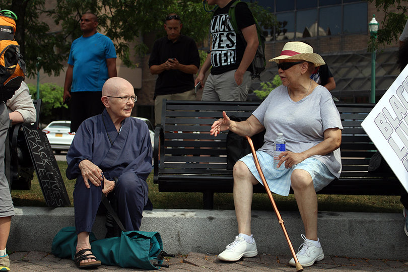 Bonnie Schultz, Buddhist Chaplain at Syracuse University's Hendricks Chapel, and protester Louis Poindexter converse about the Black Lives Matter movement before the march starts.