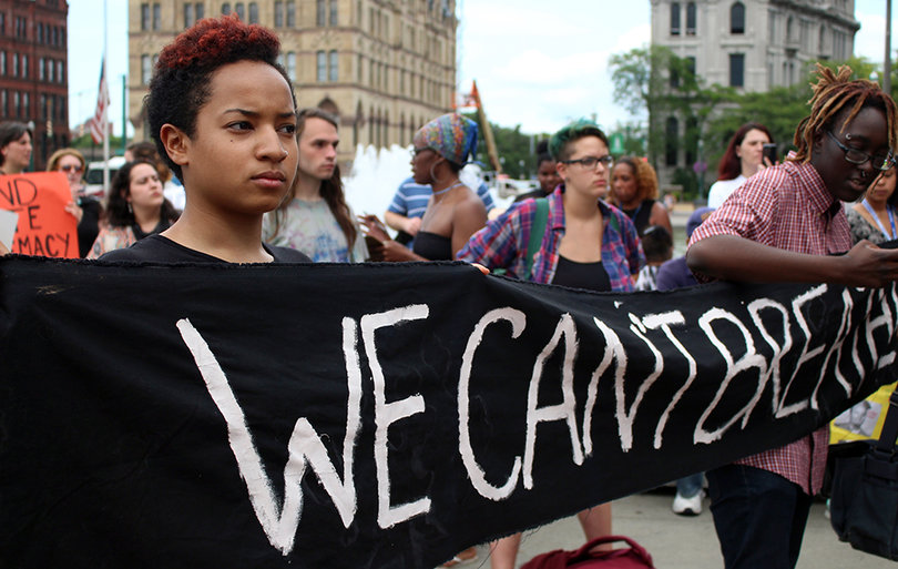 Syracuse University student Sarah Ibrahim holds a banner that says: "We can't breathe."