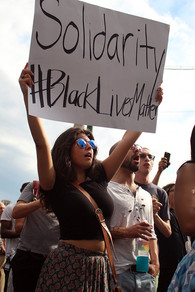 Alexis Rinck, a Syracuse University student, holds a sign promoting solidarity of races for the Black Lives Matter movement.