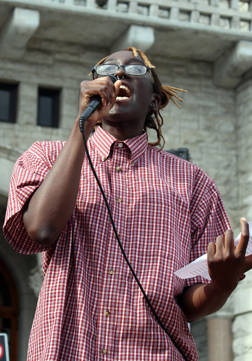 Adrianna Cummings reads a poem entitled, "As I pass out flyers," on the steps of the Federal Building in Syracuse.