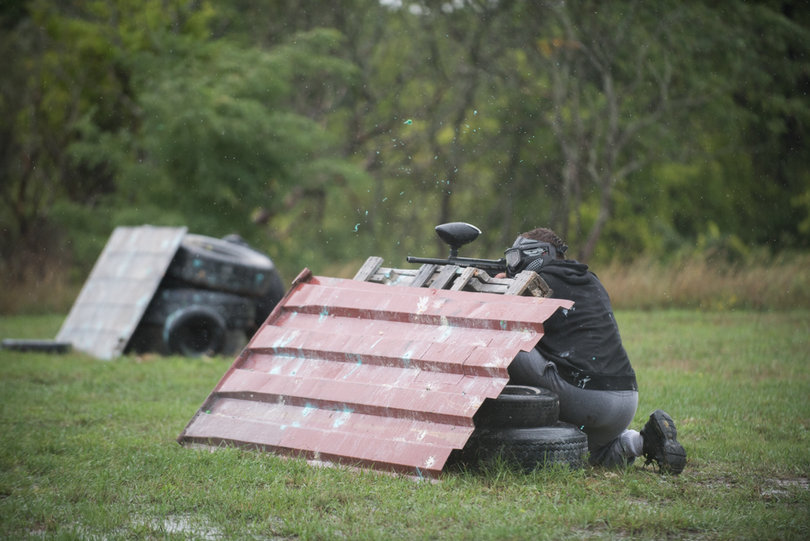 A shot explodes off a barrier as an SU player crouches.