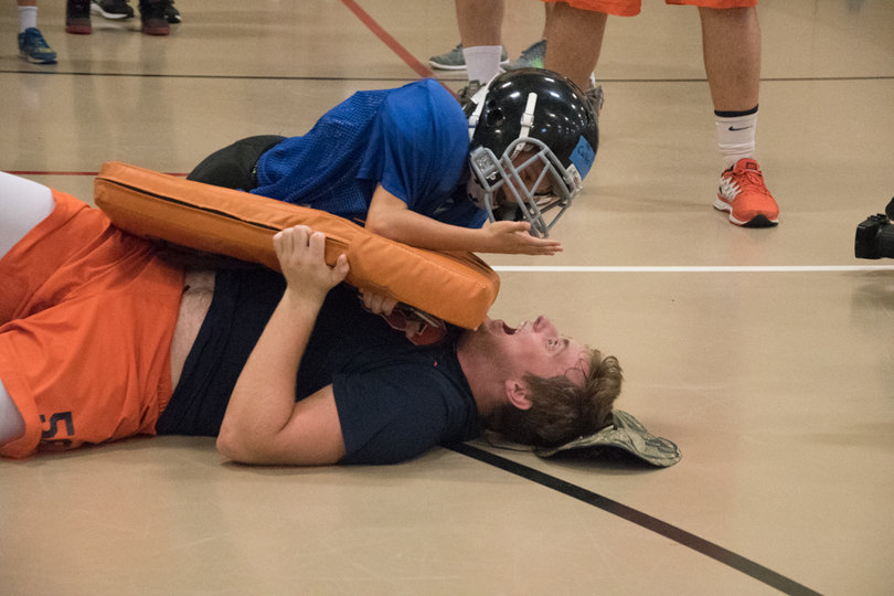 Freshman lineman Liam O'Sullivan (56) takes part in a drill during the youth clinic.