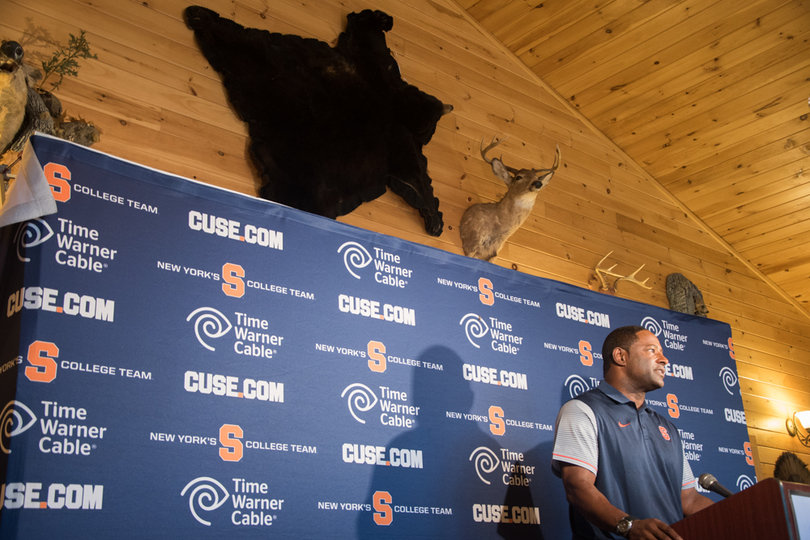 Syracuse head coach Dino Babers addresses the media in front of a bearskin.