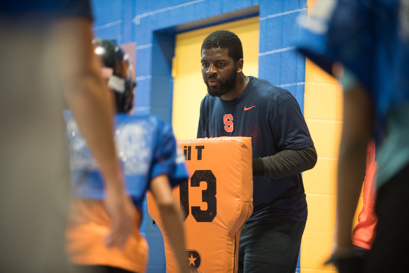 Junior linebacker Alryk Perry holds a pad up for players to hit.