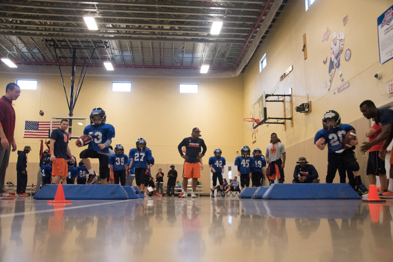 Two players carry the ball while avoiding obstacles on the court.