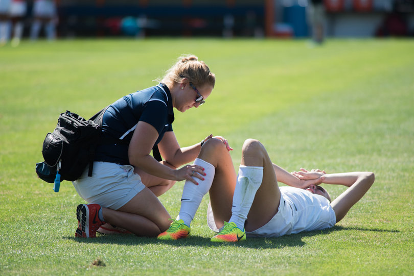 An Orange player gets tended to by a trainer.