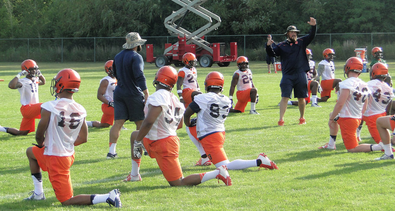 Syracuse's defensive players stretch as a unit.