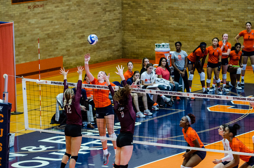 Mackenzie Weaver tries to tip a ball past the outstretched arms of the Colgate blockers.