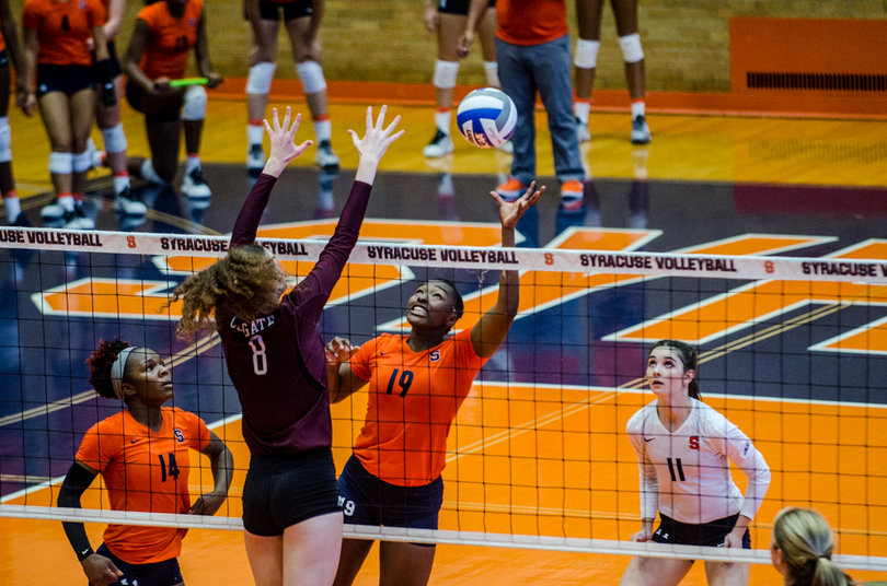 SU middle blocker Santita Ebangwese tips a ball to the Colgate side of the net as Taylor Flaherty attempts to bat it down.