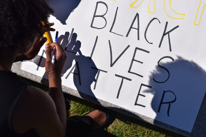 One SU student creates a poster with "Black Lives Matter" written on it for the march.