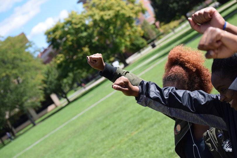 Students on the Syracuse University campus holding their fist in the air during the march. 