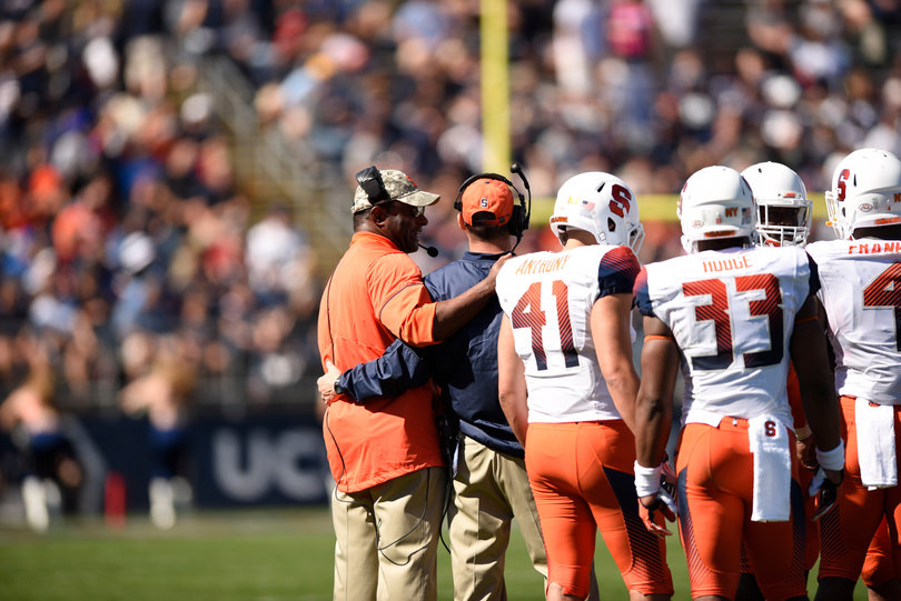 Syracuse head coach Dino Babers wraps his arm around an assistant.
