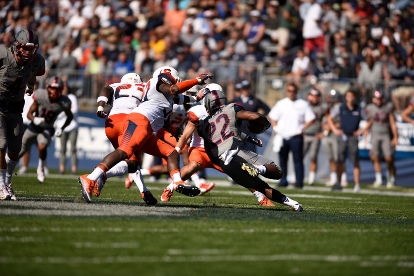 UConn running back Arkeel Newsome makes a cut while carrying the ball.