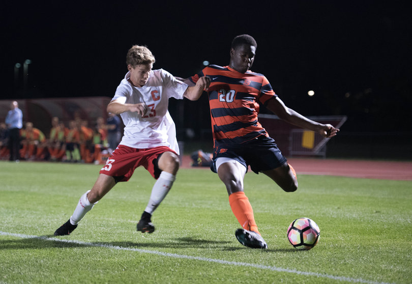 Orange defender Kamal Miller launches a ball down field as Cornell defender Riley Adams tries to disrupt the pass.