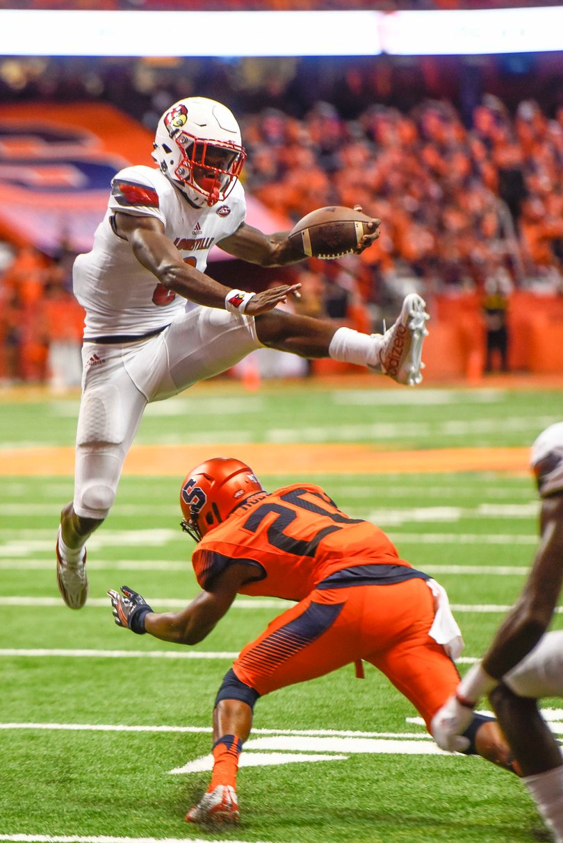 Louisville quarterback Lamar Jackson hurdles over Cordell Hudson en route to scoring a touchdown. 
