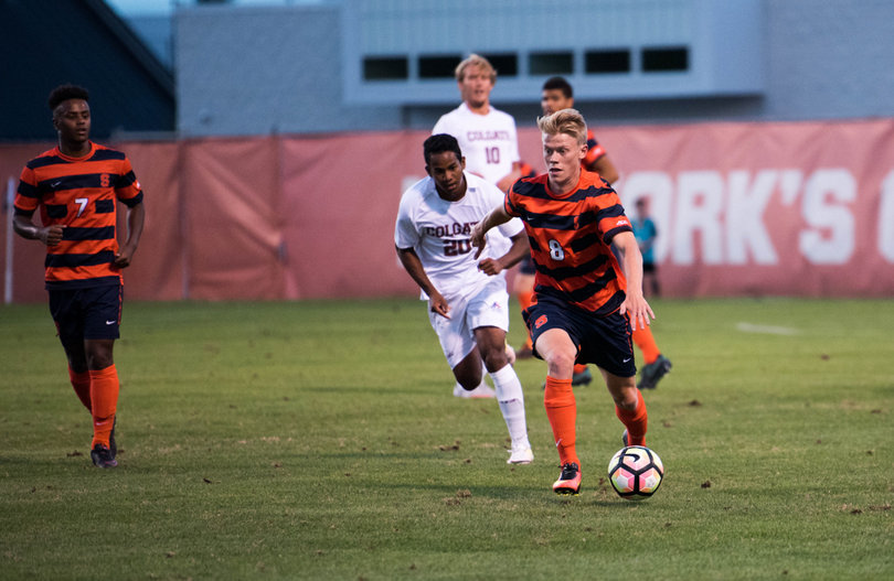 Jonathan Hagman dribbles the ball ahead of him, keeping it away from a Raiders defender. 