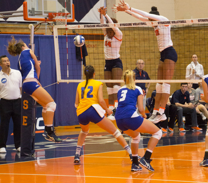 Jalissa Trotter (14) and Witherspoon block a ball at the net.  