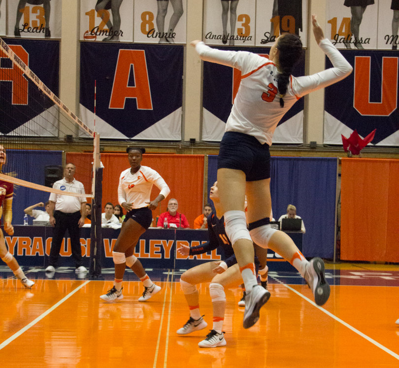 Anastasiya Gorelina jumps off the floor and lifts her arm up to prep to hit the ball.