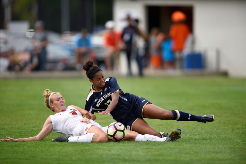 Brackett and Heard slide to the ground as the two continue to fight for the ball.
