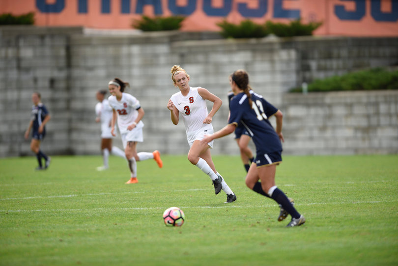 Notre Dame's Ginny McGowan moves laterally across the field, trying to avoid SU's Sydney Brackett.