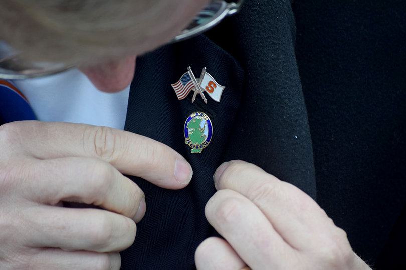 SU Chancellor Kent Syverud puts on a first responder Lockerbie pin prior to the Rose Laying Ceremony.
