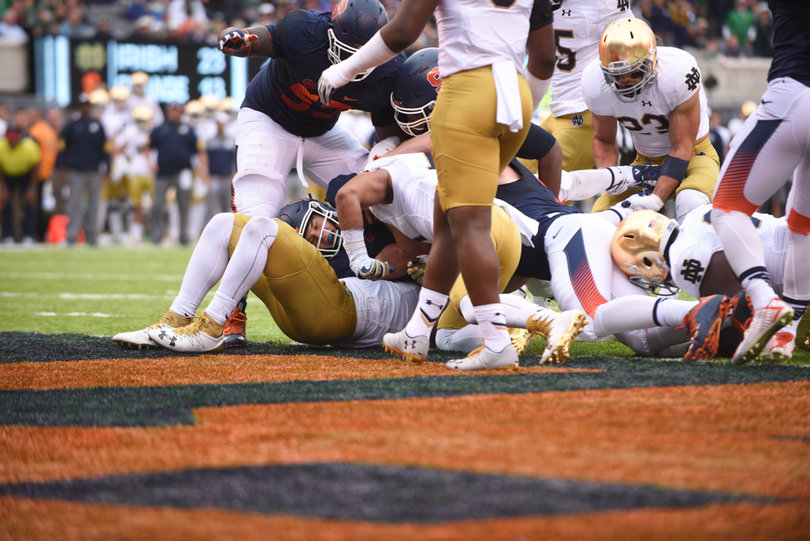 Eric Dungey lies in the middle of a pile at the goal line, waiting for a touchdown signal.