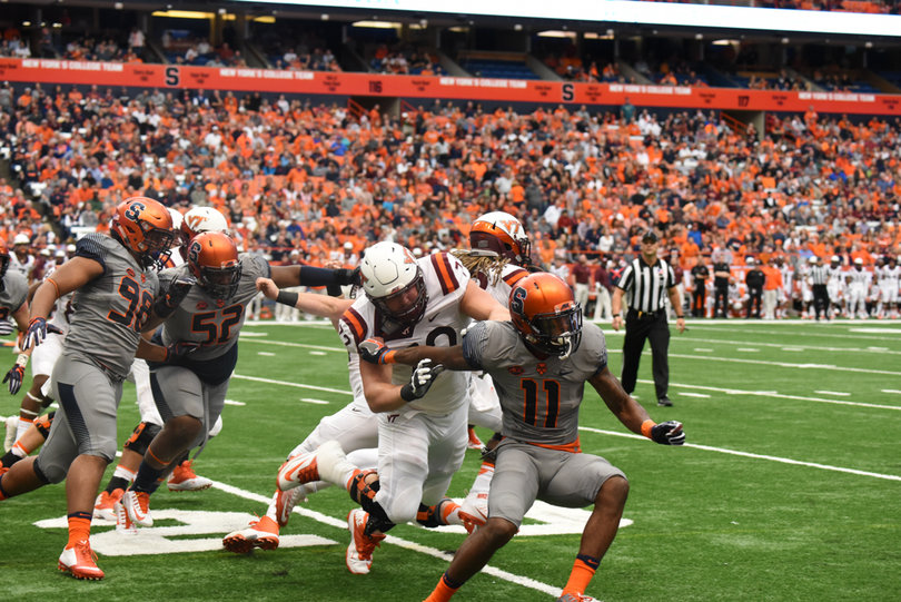 Corey Winfield tries to shed a Hokie blocker as defensive linemen McKinley Williams and Kayton Samuels chase down VT players. 