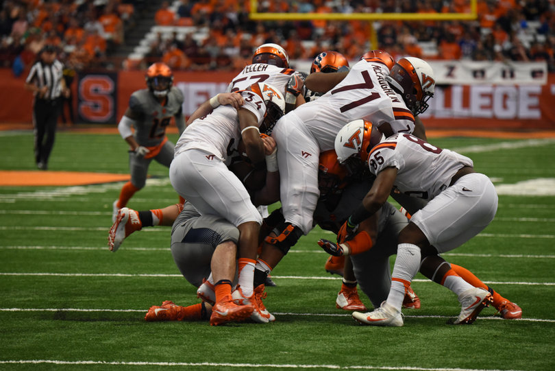 Virginia Tech players and Syracuse players collide as SU stuffs Travon McMillian, who rushed just nine times for 39 yards. 