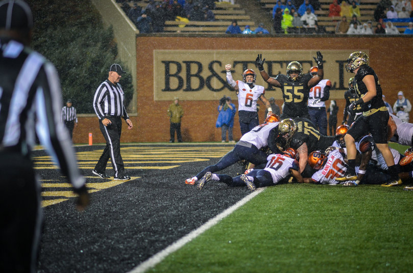 A pile-up unfolds along the goal line as referees look to make a call.