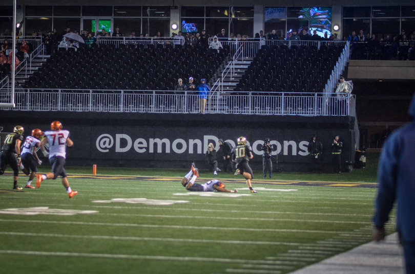 Wake Forest quarterback John Wolford gets into open space as a Syracuse defender slides on the turf.