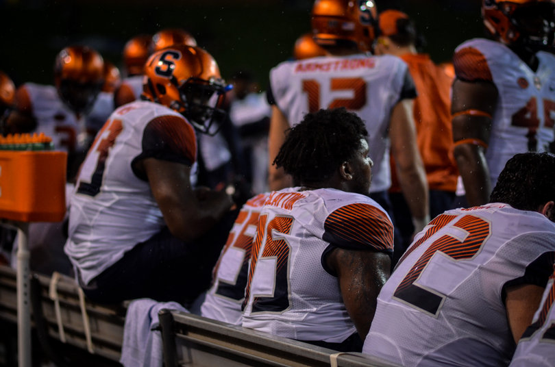 Members of the Orange's defensive line sit on SU's bench. Wake Forest had possession for just over 8 more minutes than Syracuse.