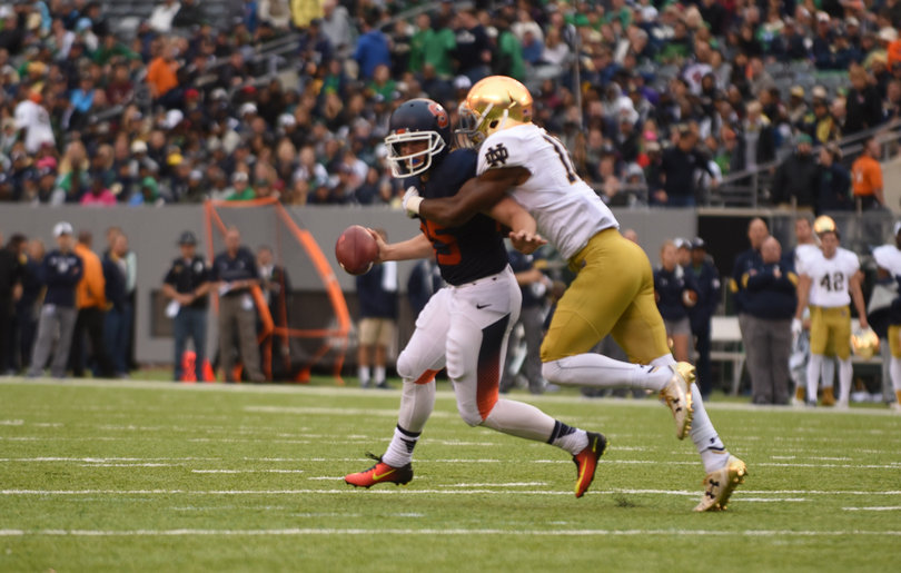 Syracuse punter and holder Sterling Hofrichter is dragged down after he bobbled the snap on an extra point attempt, forcing him to run for it.