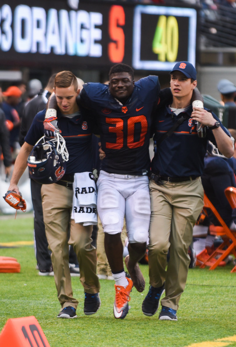 Orange linebacker Parris Bennett is helped off the field following an apparent injury to his left ankle.