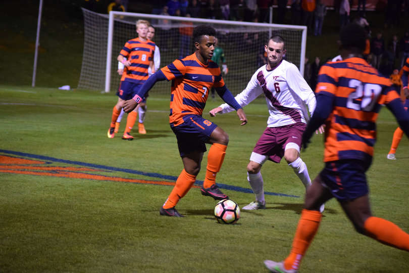 Syracuse midfielder Mo Adams possess the ball in the middle of the field, attempting to make a move around VT's Brendan Moyers.