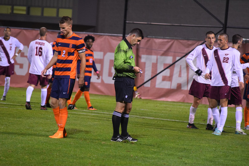 Orange captain Oyvind Alseth (2) walks away from the referee as the official jots something in his notebook.