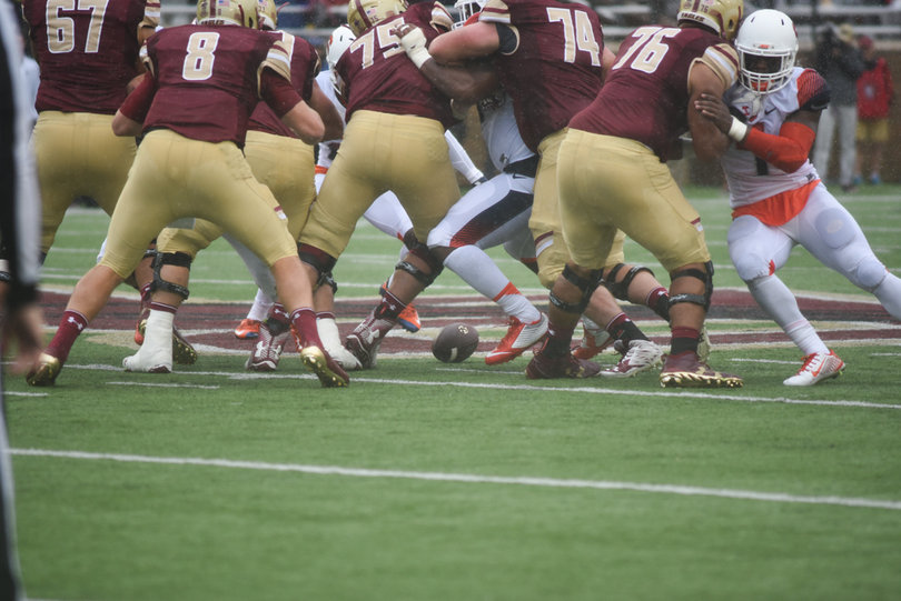 The football drops to the turf as both teams jostle for position.