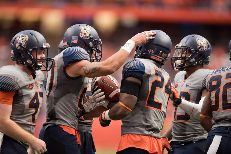 Syracuse players gather with the ball. SU stayed in the game until late in the fourth quarter.