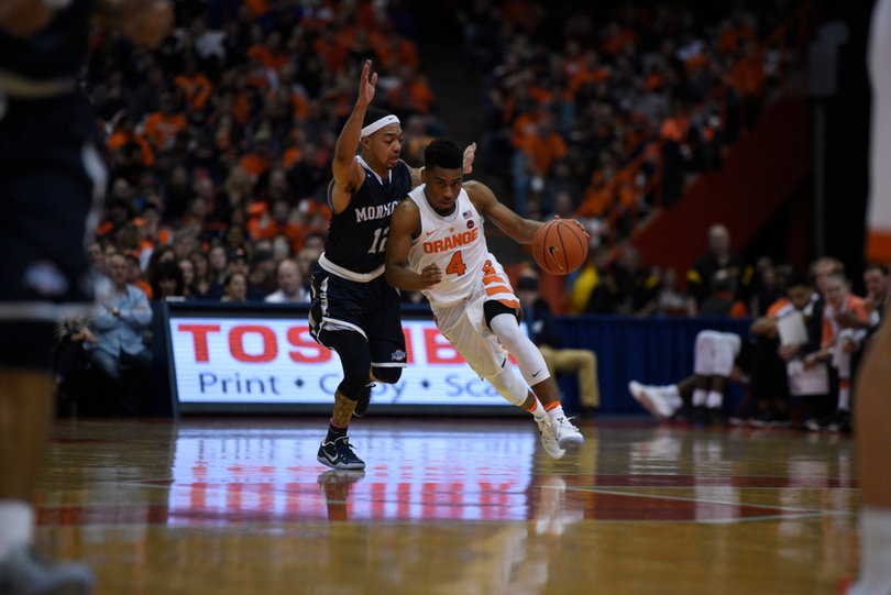 John Gillon uses his body to protect the ball and get around Monmouth's Justin Robinson.