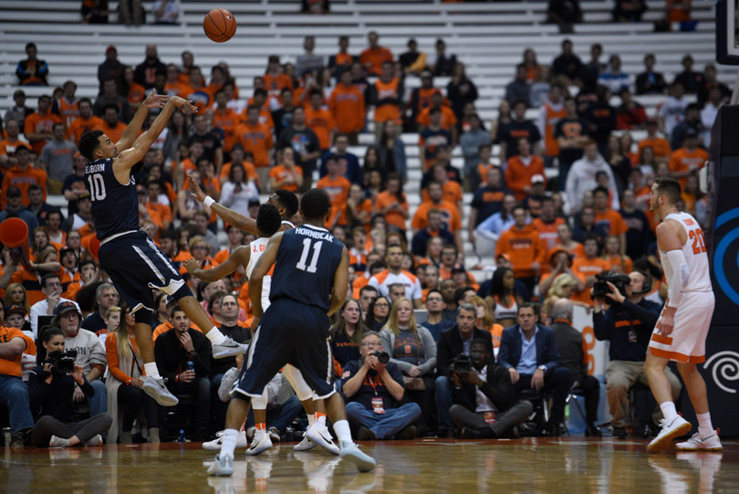 Monmouth's Micah Seaborn launches a jumper in the corner as Syracuse's defense collapses on him.