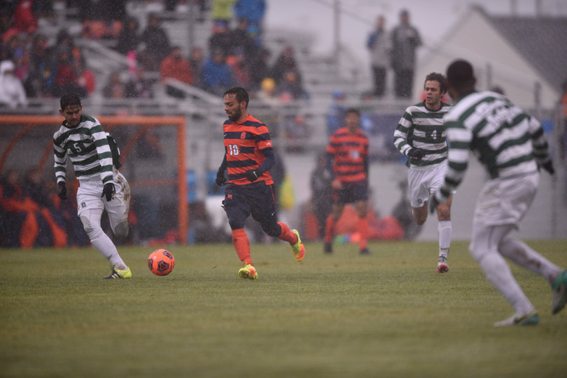 Camargo pushes the ball forward in possession while three Dartmouth defenders look on.