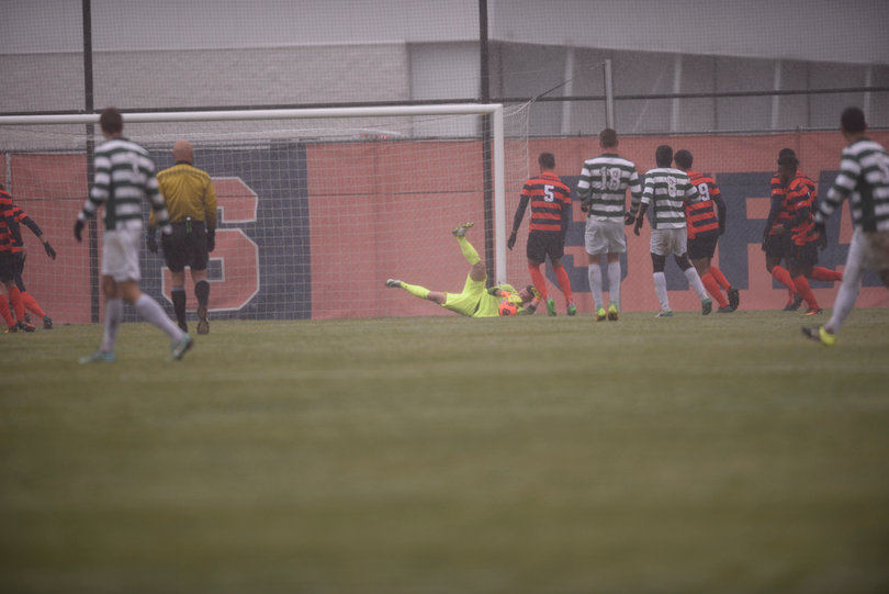 Syracuse goalie Hendrik Hilpert jumps on top of a loose ball in the box.