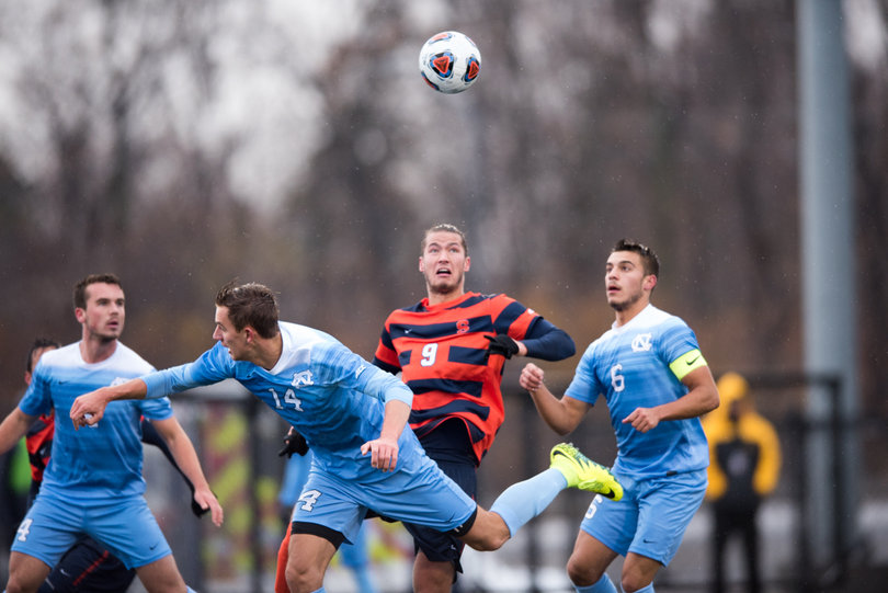 Syracuse Johannes Pieles goes up for a header in the middle of three Tar Heels defenders.