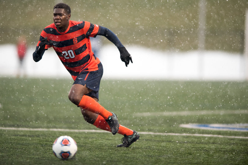 SU defender Kamal Miller runs through the wet conditions.