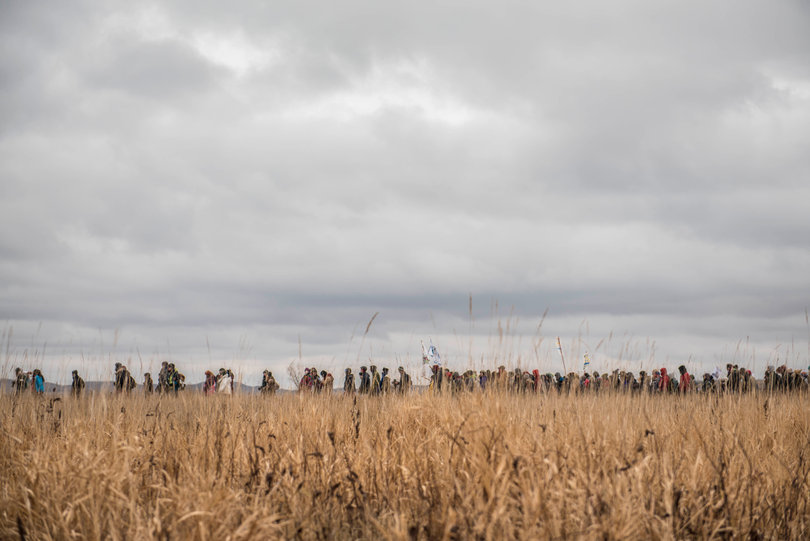 Women march from the Geo Dome in the Oceti Sakowin camp on Thanksgiving Day to show support after the initial wave of protectors gathered at the river.