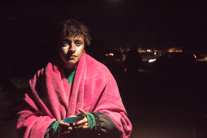 Jules from Philadelphia, Pennsylvania, recovers at the Mess Hall at Oceti Sakowin main camp after gathering at the barricade. White from milk of magnesia streaks her face as a result of being treated by Emergency medics for tear gas.